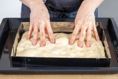 Vertiefungen in die Focaccia drücken