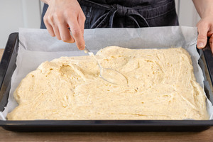 Teig für den Boden des Mandelkuchens auf dem Backblech verstreichen