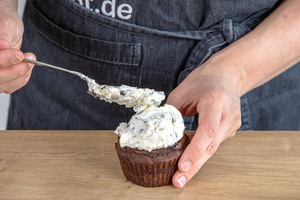 Sahne-Topping auf den Maulwurf-Muffins verteilen