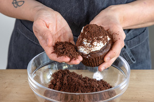 Maulwurf-Muffins mit zerkrümeltem Rührteig bestreuen