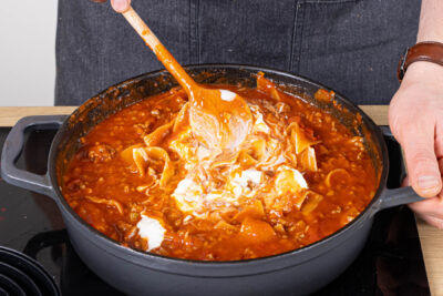 Frischkäse und Sahne unter die Pfannen-Lasagne rührenrichtig