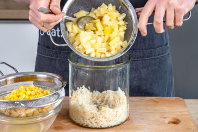 Ananas in Salatschüssel schichten