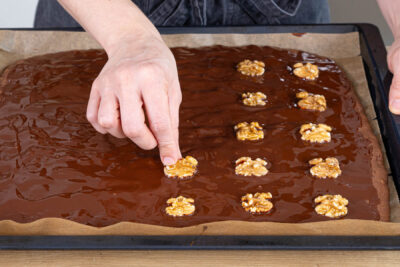 Walnusskuchen vom Blech mit Glasur und Walnüssen verzieren