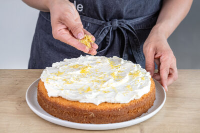 Zitronenkuchen mit Lemon-Curd-Füllung mit Zitronenabrieb dekorieren