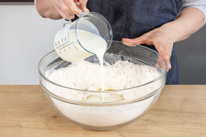 Buttermilch zu den trocknen Zutaten in die Schüssel gießen