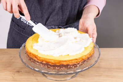 Sahne auf Eierlikör-Käsekuchen verteilen