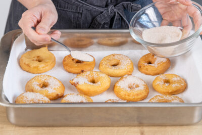 Apfelkrapfen mit Zucker bestreuen