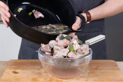 Fleisch und Lauch durch ein Sieb geben