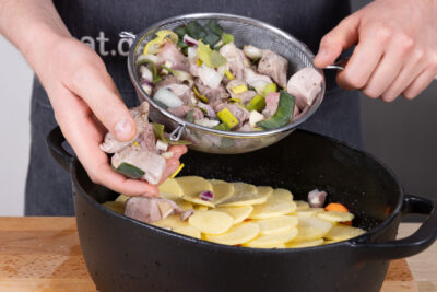 Fleisch und Lauch über Kartoffeln verteilen