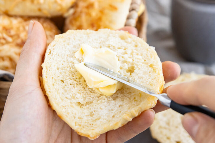 Fluffige Käsebrötchen mit Butter bestreichen
