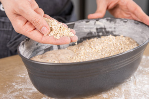 Haferflockenbrot mit Haferflocken bestreuen