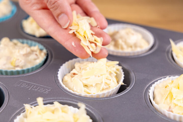 Käse-Schinken-Muffins mit Käse bestreuen