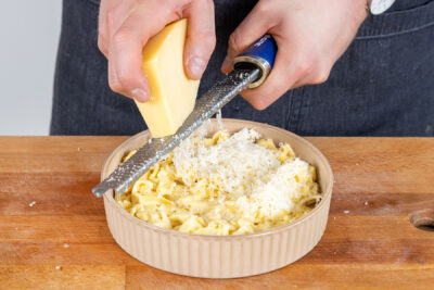 Käse über die Spätzle in der Auflaufform reiben
