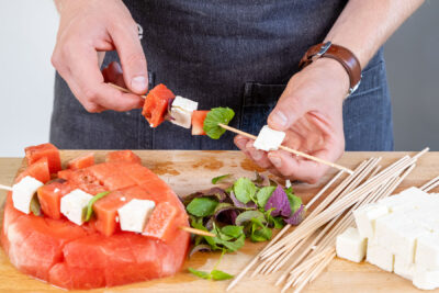 Melonen, Feta und Minze abwechselnd auf die Spieße stecken