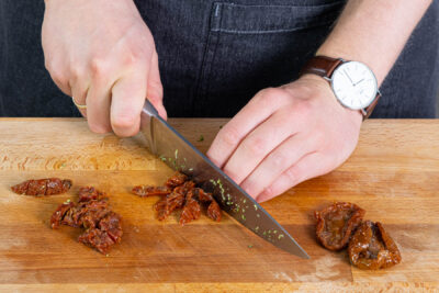 getrocknete Tomaten abtropfen lassen und klein schneiden