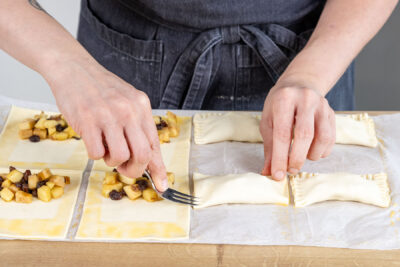 Ränder der Apfeltaschen mit der Gabel zusammendrücken