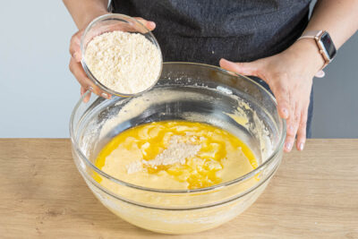 Butter und Mandeln zum Rührteig geben