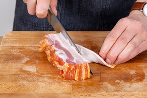 Schwarte vom Speck schneiden