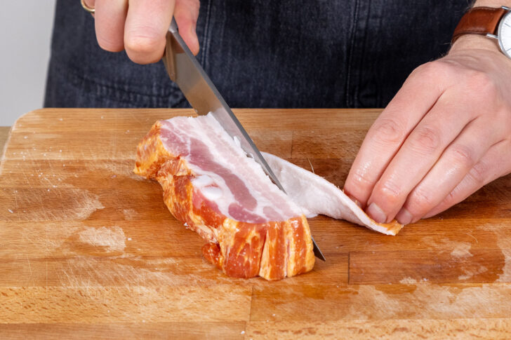 Schwarte vom Speck schneiden