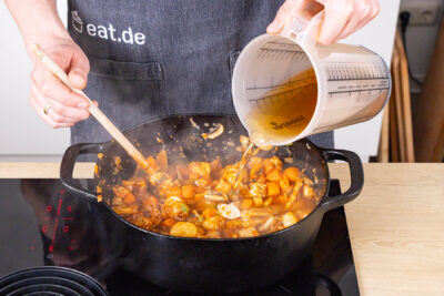 Putengulasch mit Weißwein ablöschen sowie mit Brühe auffüllen