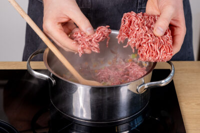 Hackfleisch in den Topf zu den Gemüsewürfeln geben