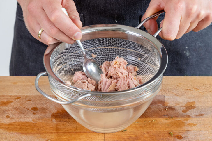 Thunfisch in ein Sieb geben