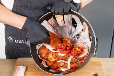 Fleisch und Gemüse in den Topf schichten