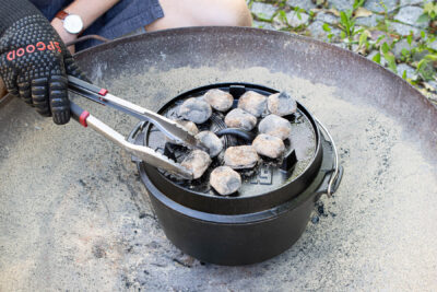angeheizte Briketts unter und auf dem Dutch Oven verteilen