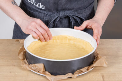 Boden für die Quarktorte andrücken