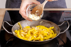 Knoblauch zur den gebratenen Paprika geben
