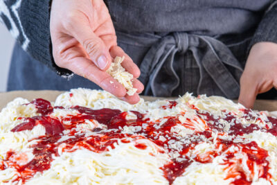 Schokoraspel über dem Spaghetti-Kuchen vom Blech verteilen