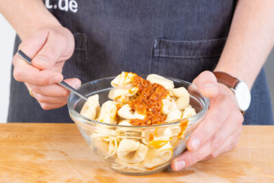 Pesto mit Tortellini vermischen.
