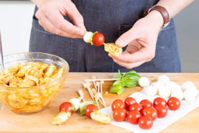 Tortellini, Mozzarella, Basilikum und Tomaten aufspießen.