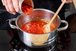 gehackte Tomaten in den Topf geben