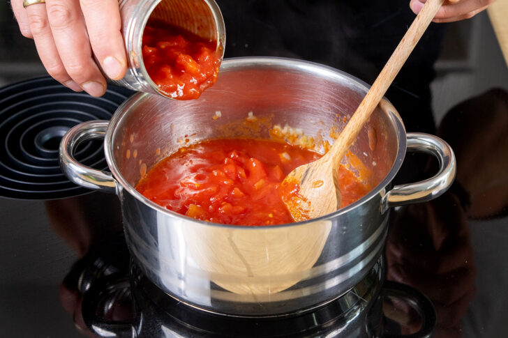 gehackte Tomaten in den Topf geben