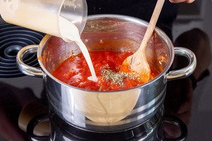 Sahne zu den Tomaten geben