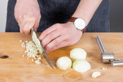 Zwiebeln in fiene Würfel schneiden, Knoblauch pressen