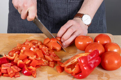 Tomaten und Paprika in mundegerechte Stücke schneiden