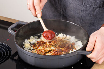 Gewürze und Tomatenmark ebenfalls anschwitzen