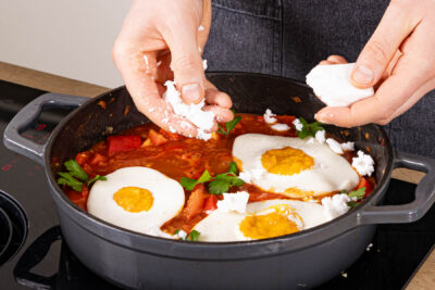 Veganes Shakshuka mit veganem Feta und Petersilie garnieren