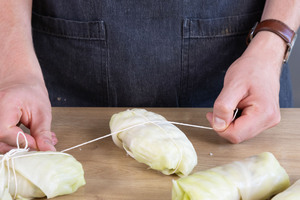 Die vegetarischen Krautwickel binden.