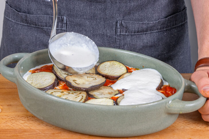 Bechamelsauce über den Auflauf geben