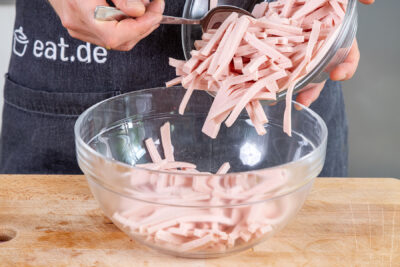 Wurststreifen in eine Schüssel geben