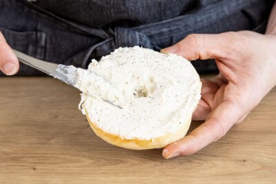 Bagel mit Kräuterfrischkäse bestreichen