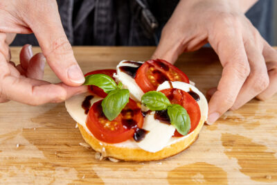 Basilikum zur Tomate und Mozzarella geben