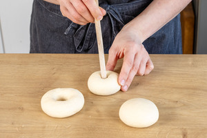 Mit Holzstiel ein Loch in die Bagels stechen