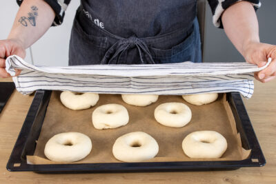 geformte Bagels mit einem Küchentuch abdecken