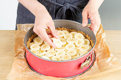 Bananenscheiben auf der Karamellschicht verteilen