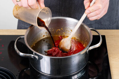 Balsamico und Wasser zur Sauce geben und aufkochen