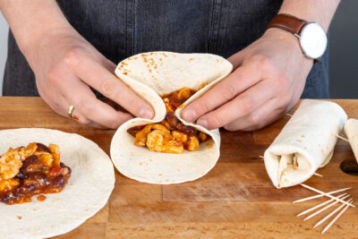 Seiten der Tortillas einklappen und zusammenrollen